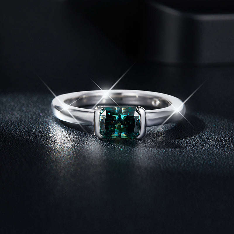 CARISSIE radiant moissanite bezel ring, front view showcasing the 5x7mm teal gemstone secured by corner metal bars