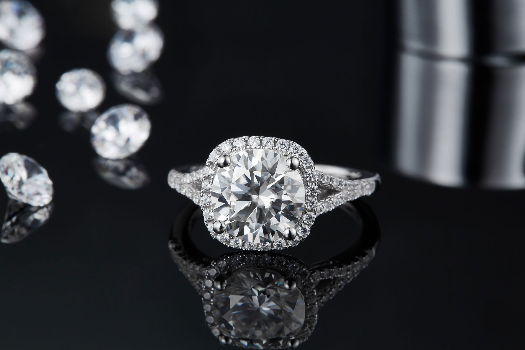CARISSIE round moissanite halo engagement ring, front view on reflective surface displaying clear mirror image and full halo circumference