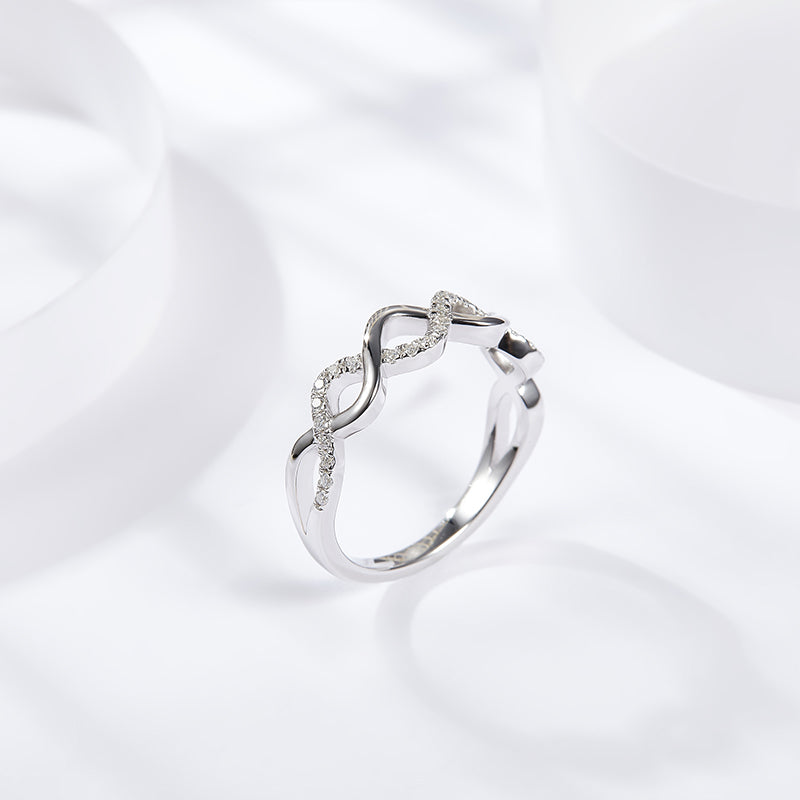 CARISSIE round moissanite pavé wedding band, diagonal perspective highlighting the fluid curve of the polished metal and stone setting.