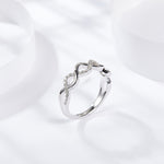 CARISSIE round moissanite pavé wedding band, diagonal perspective highlighting the fluid curve of the polished metal and stone setting.