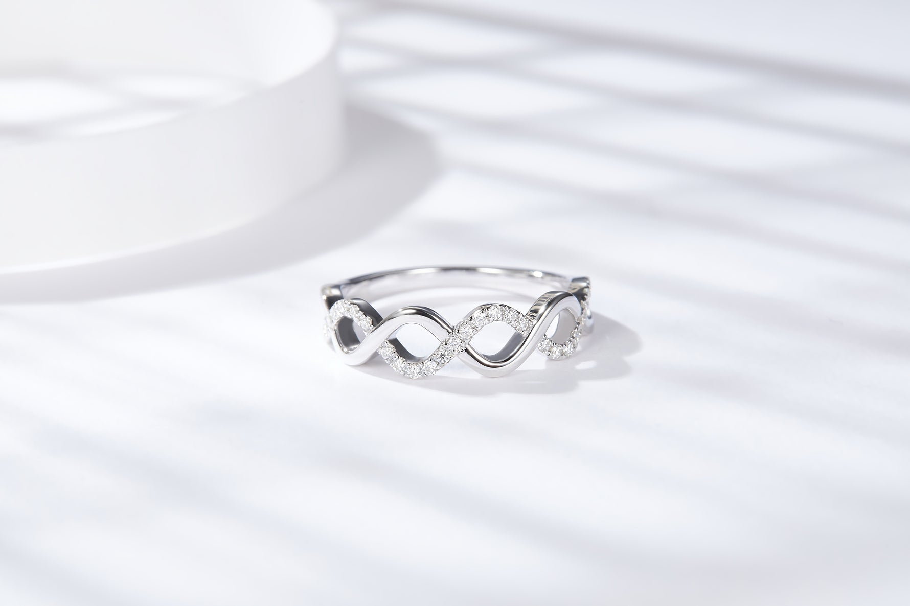 CARISSIE round moissanite pavé wedding band, close-up view emphasizing the brilliance of the small round stones along the wave.