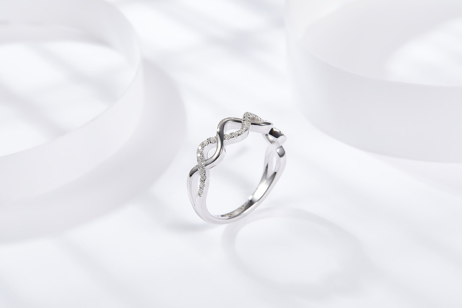 CARISSIE round moissanite pavé wedding band, elevated angle showcasing the delicate height of the wavy design against a clean background.