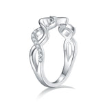 CARISSIE round moissanite pavé wedding band, side profile revealing the undulating silver-tone shank and open interior structure.