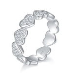 CARISSIE eternity band, angled view displaying alternating heart-shaped links with pavé-set moissanite stones and S925 interior stamp