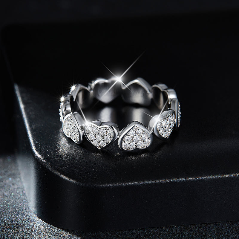 CARISSIE eternity band, lifestyle shot placed on black jewelry box showing the ring's silhouette and brilliant stone brilliance under studio lighting