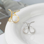 CARISSIE pavé statement rings in two colors resting on a white ceramic plate surface