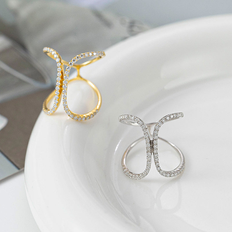 CARISSIE pavé statement rings in two colors resting on a white ceramic plate surface