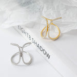 CARISSIE pavé statement ring in gold and silver tones, angled view on book showing butterfly shape