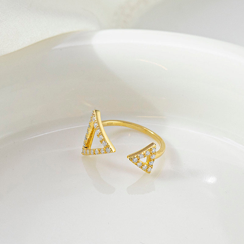 CARISSIE round moissanite pavé engagement ring, close-up of yellow gold model featuring solid stone-encrusted triangle end