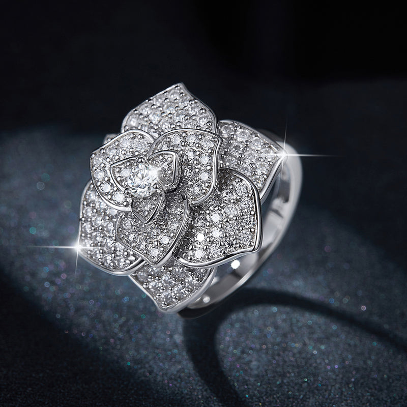 CARISSIE pavé-set flower ring, close-up shot against dark background emphasizing the sparkle of the stones