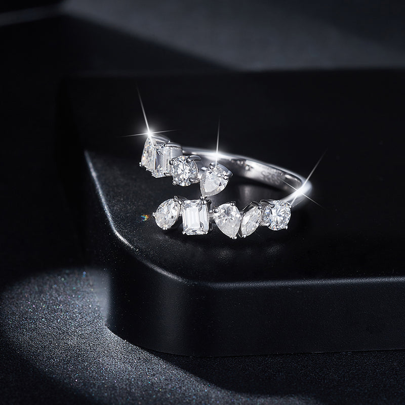 CARISSIE mixed-cut moissanite bypass ring, dramatic studio shot on black surface emphasizing high sparkle and brilliance