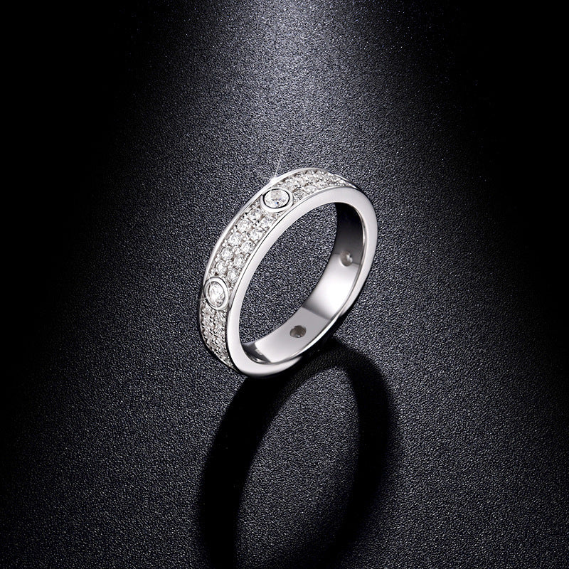CARISSIE round moissanite eternity band standing upright on dark surface, dramatic lighting emphasizing ring silhouette and sparkle