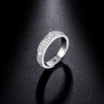 CARISSIE round moissanite eternity band standing upright on dark surface, dramatic lighting emphasizing ring silhouette and sparkle