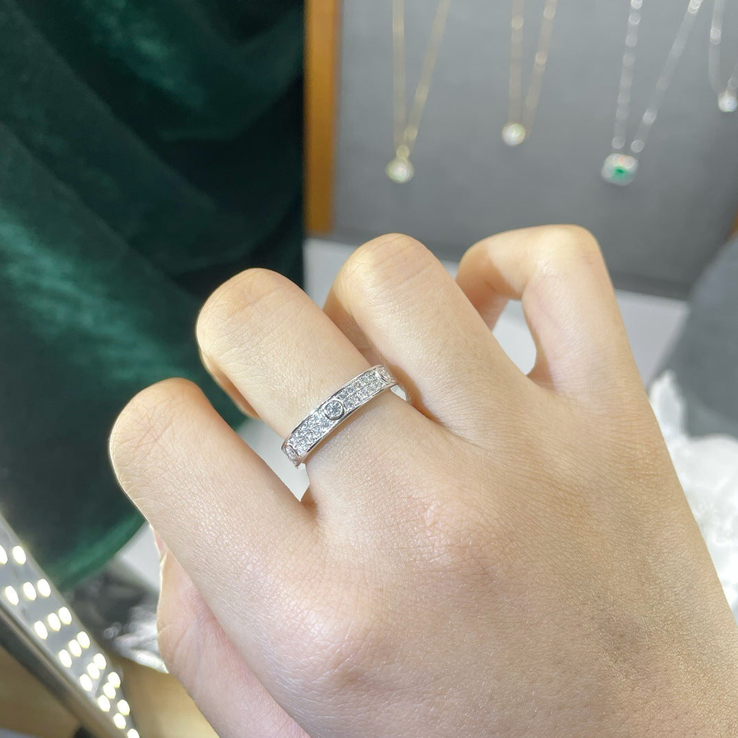 CARISSIE round moissanite eternity band worn on hand, angled view showing dual-row pavé and bezel-set stones