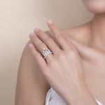 CARISSIE round moissanite pavé engagement ring on model hand, showcasing the organic floral cluster design and split shank band