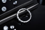 CARISSIE round moissanite eternity band, top-down view resting on tweezers showcasing the smooth inner gallery and precise craftsmanship details