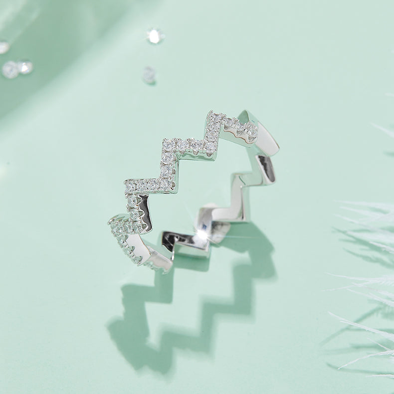 CARISSIE round moissanite pavé ring, artistic angle emphasizing the architectural depth and light reflection on the silver-tone metal