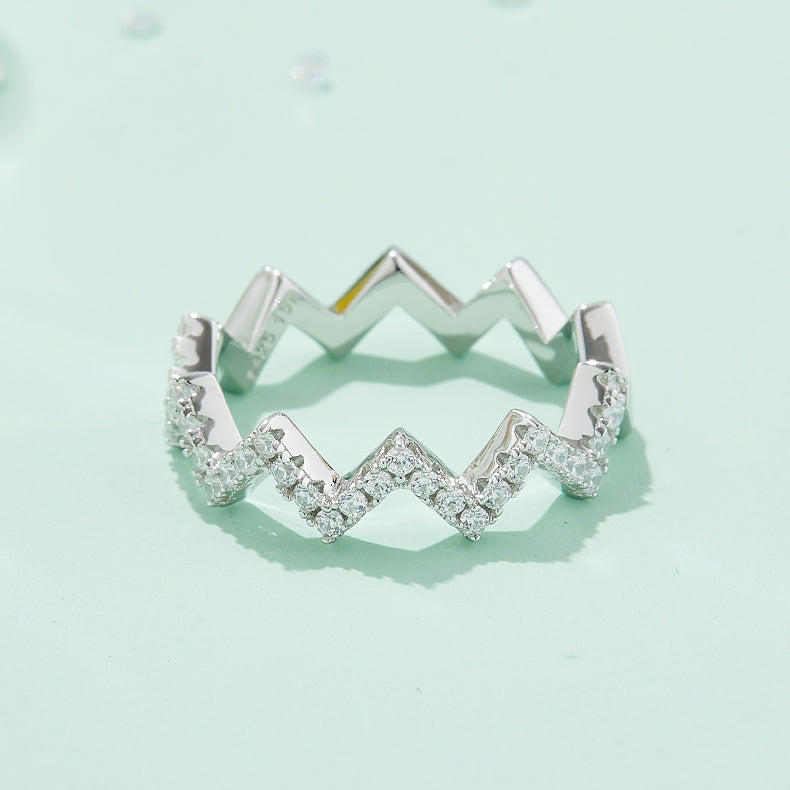 CARISSIE round moissanite pavé ring, close-up view highlighting the brilliant-cut stones set along the sharp V-shaped points of the band