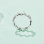 CARISSIE round moissanite pavé ring, lifestyle shot on a mint green background casting a distinct zigzag shadow