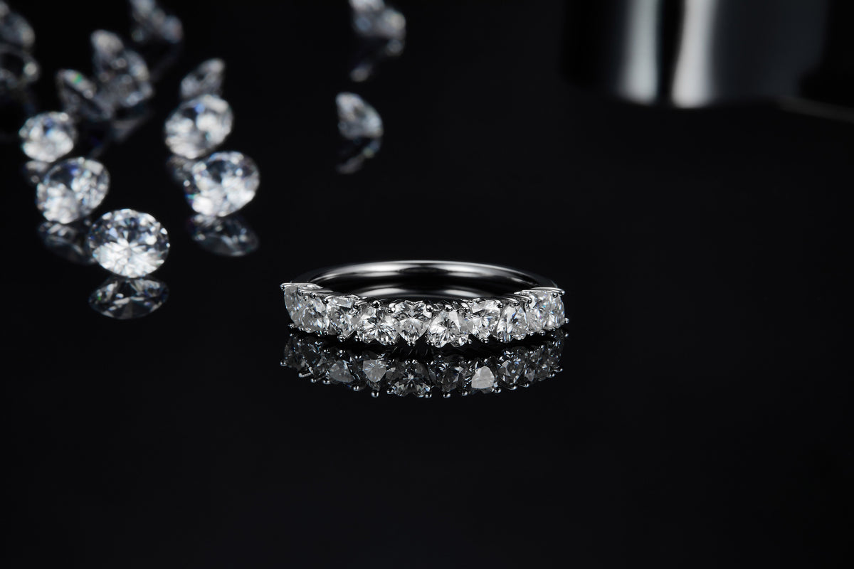 CARISSIE round moissanite eternity band, close-up with tweezers revealing detailed craftsmanship and inner gallery