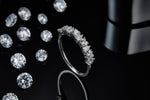 CARISSIE round moissanite eternity band, side perspective showing polished silver metal shank and gemstone alignment