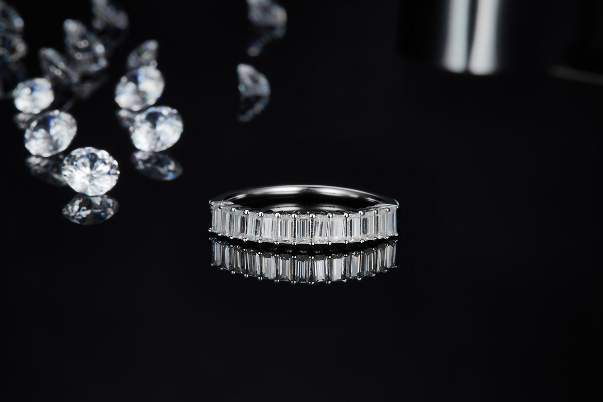 CARISSIE eternity band, low angle front view emphasizing the geometric precision of the faceted baguette-cut stones