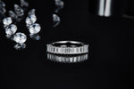 CARISSIE eternity band, low angle front view emphasizing the geometric precision of the faceted baguette-cut stones