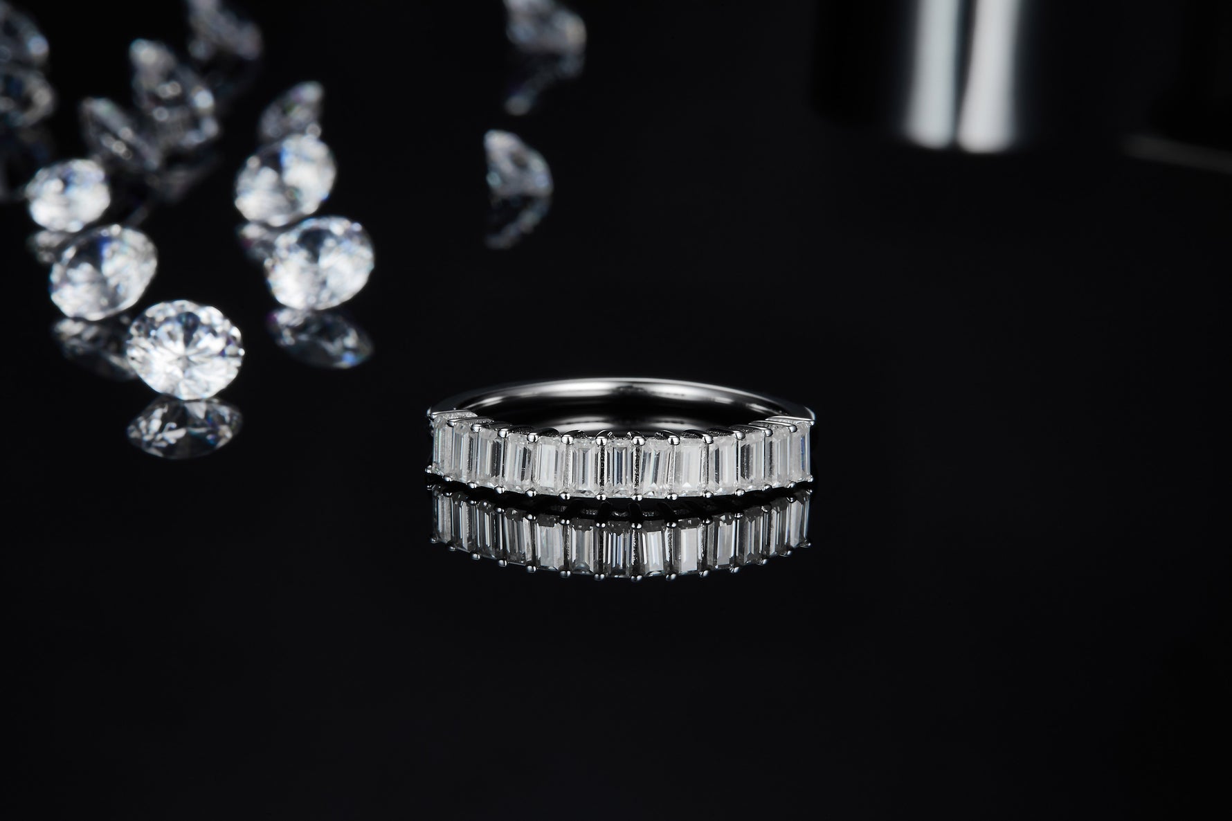 CARISSIE eternity band, low angle front view emphasizing the geometric precision of the faceted baguette-cut stones