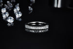 CARISSIE Princess Moissanite Eternity Band, horizontal side profile on a dark mirror base emphasizing the perfect symmetry of the geometric stones.