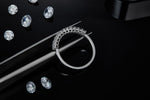 CARISSIE Princess Moissanite Eternity Band, close-up held by tweezers showing the craftsmanship of the metal band and uniform prong placement.