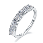 CARISSIE round moissanite eternity band, angled view highlighting the four-prong setting and polished silver-tone shank.