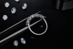 CARISSIE round moissanite eternity band, side profile held by tweezers revealing the open gallery and prong structure.