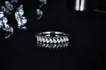 CARISSIE round moissanite solitaire ring, front-facing angle on a glossy surface showing the reflection of the row of round stones and sleek band