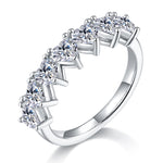 CARISSIE heart moissanite eternity band, angled view highlighting the vertical prong settings and polished silver-tone shank.