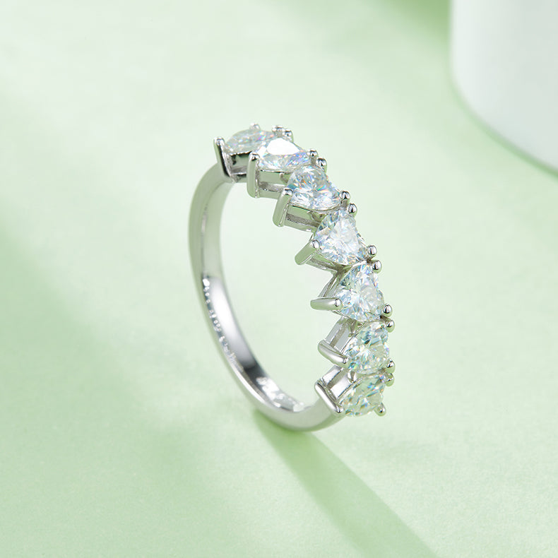 CARISSIE heart moissanite eternity band, diagonal shot displaying the smooth curve of the ring band and secure stone placement.