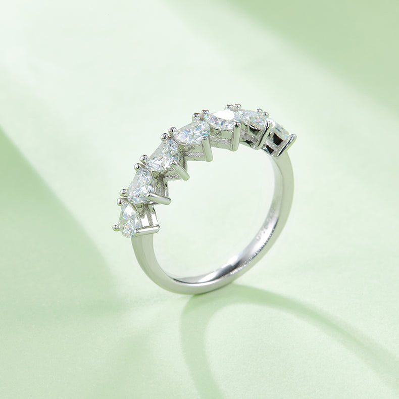 CARISSIE heart moissanite eternity band, side angle on soft green background emphasizing the sparkle and height of the prong setting.