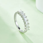 CARISSIE princess moissanite eternity band, vertical perspective on soft surface showcasing the continuous half-eternity design