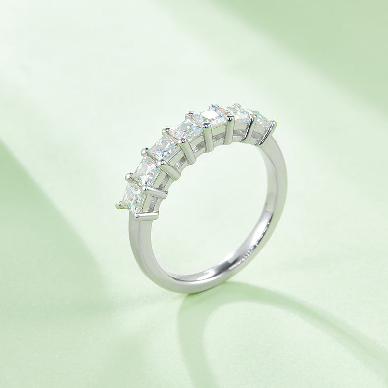 CARISSIE princess moissanite eternity band, lifestyle shot on green background emphasizing sparkle and light reflection