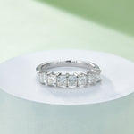 CARISSIE princess moissanite eternity band, side angle on white pedestal displaying S925 stamp inside band