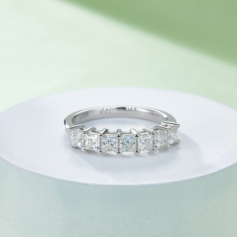 CARISSIE princess moissanite eternity band, side angle on white pedestal displaying S925 stamp inside band