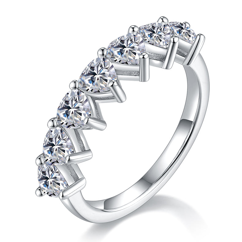 CARISSIE heart moissanite eternity band, angled view showing ladder prong setting and brilliant stones on polished silver-tone metal