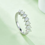 CARISSIE pear moissanite eternity band, lifestyle shot capturing the brilliant sparkle of the stones against a soft green surface