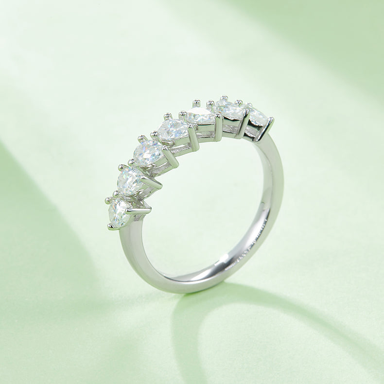 CARISSIE pear moissanite eternity band, side angle on mint green background emphasizing the stone height and band thickness