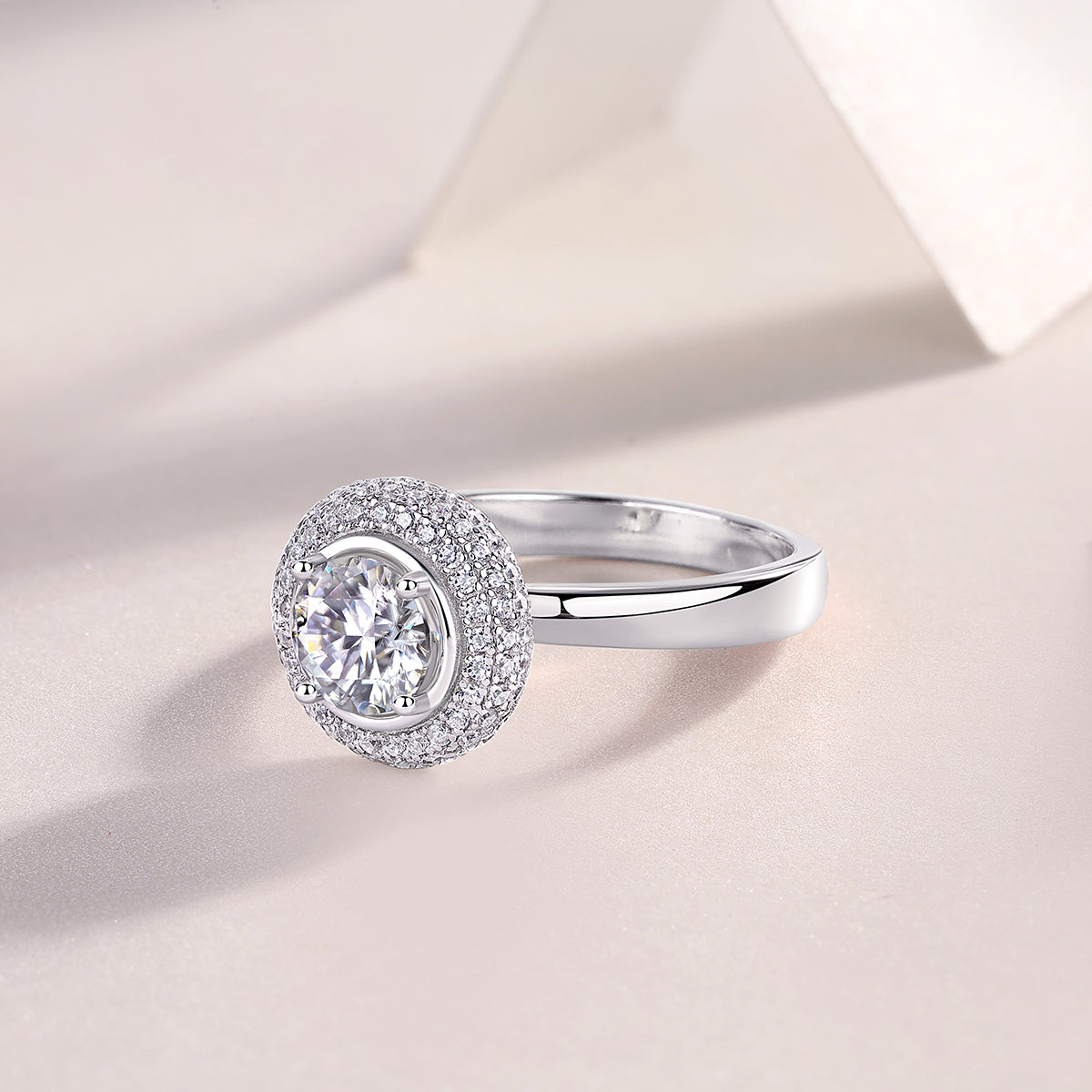 CARISSIE round moissanite halo engagement ring, diagonal perspective displaying the full circumference of the diamond-encrusted halo