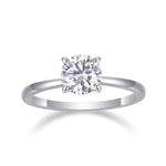 CARISSIE round moissanite solitaire ring side profile view in white gold, showcasing sleek band tapering toward four-prong setting