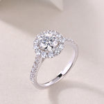 CARISSIE round moissanite halo engagement ring, three-quarter perspective capturing light reflection across the entire silver-tone band