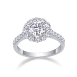 CARISSIE round moissanite halo engagement ring, angled studio view showcasing prong setting and diamond-encrusted shoulders