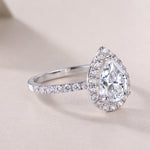 CARISSIE pear moissanite halo ring, close-up diagonal view capturing the intricate halo setting and polished finish of the metal