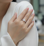 CARISSIE pear moissanite solitaire ring worn on hand, highlighting the silver-tone metal and elegant three-stone design