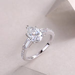 CARISSIE pear moissanite ring angled studio shot, capturing light reflection on the facets and polished silver finish